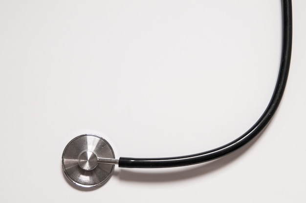 Free photo close up view of black stethoscope on white back