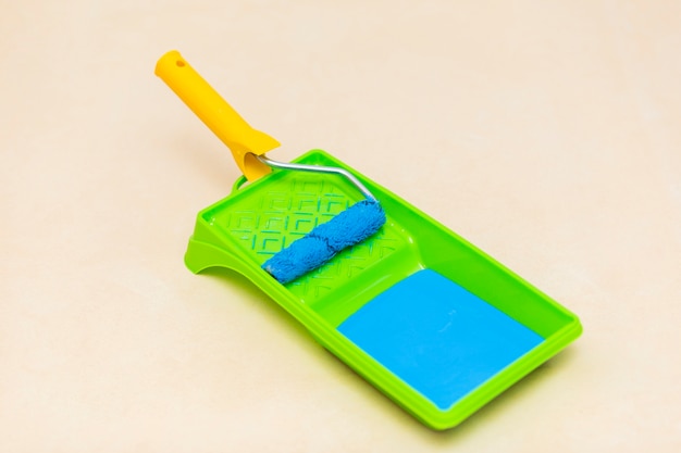 Close-up view of blue paint and paint roller