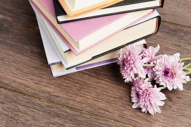 Close-up view of books and flower on wooden table