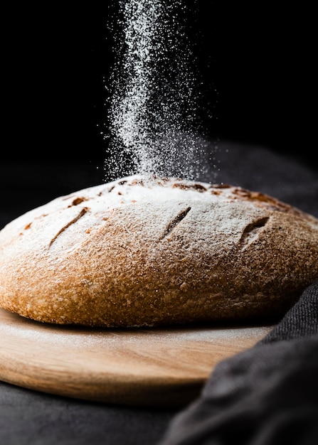 Close-up view of bread on chopper with black background