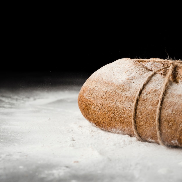 Close-up view of bread and flour on black background