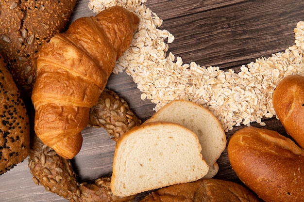 Close-up view of breads as japanese butter roll white bread with oat-flakes on wooden background