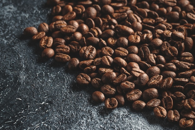 Close up view of brown coffee seeds on dark 