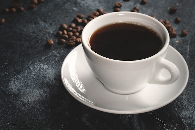 Close up view of brown coffee seeds with coffee on dark 