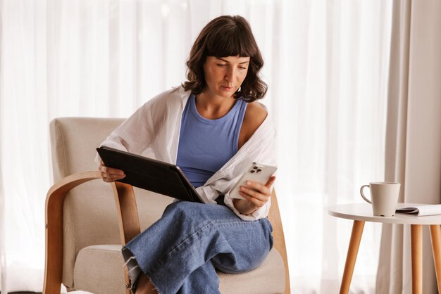 Close up view of business woman sitting in chair in room looking at phone