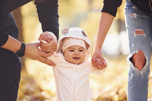Крупным планом вид. веселая семья весело вместе со своим ребенком в красивом осеннем парке.