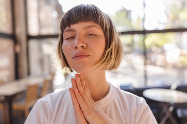 Free photo close up view of cheerful woman smiling with close eyes