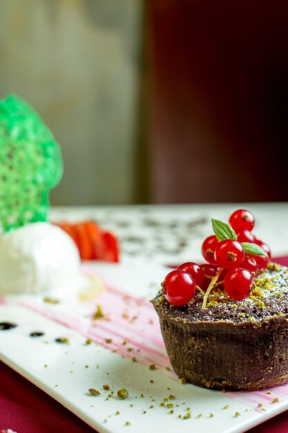 Close up view of chocolate muffin with red fresh currant