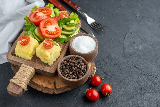 커팅 보드와 향신료 칼 붙이 검은 색 표면에 설정에 다진 및 전체 신선한 야채 치즈의 뷰를 닫습니다