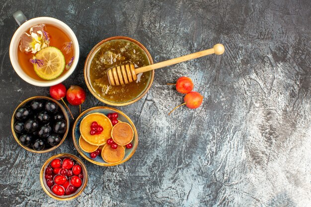 Close up view of classic pancakes served with honey and a cup of tea