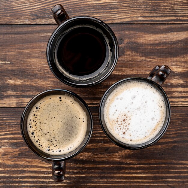 Close-up view of coffee cups on wooden table