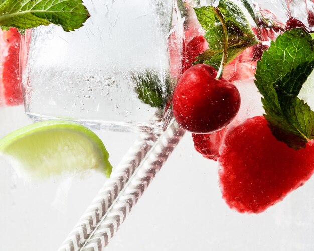 Close up view of the cold and fresh lemonade with bright berries in neon light