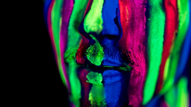 Close-up view of colorful fluorescent make-up on face
