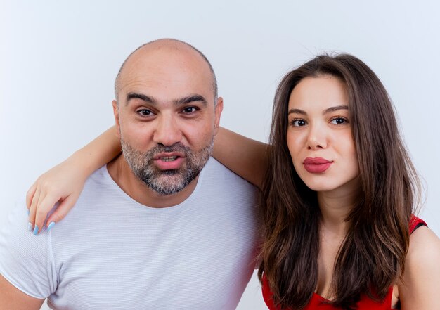 Close-up view of confident adult couple woman putting hand on man's shoulder both looking 