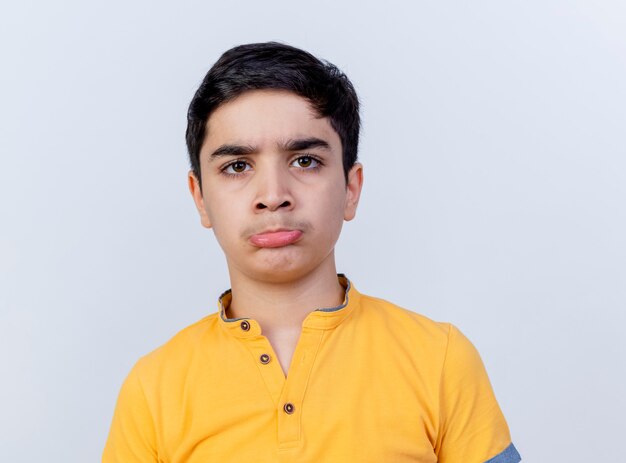 Close-up view of confused young caucasian boy looking at camera isolated on white background