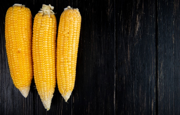 Close-up view of cooked whole corns on black background with copy space