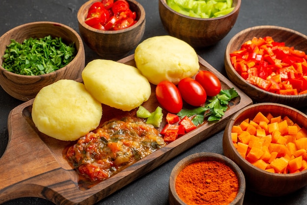 Крупным планом вид приготовления со свежими овощами и нарезанными продуктами на черном столе