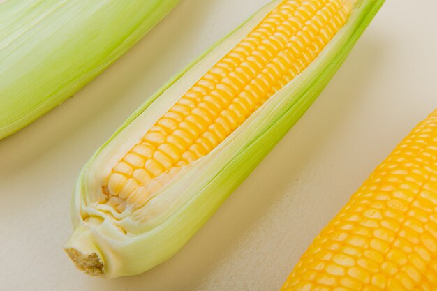 Close-up view of corn cobs on white table