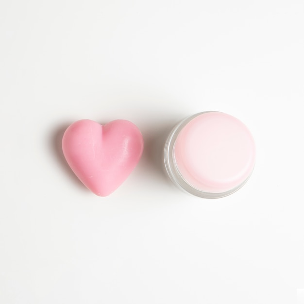 Close-up view of a cream and heart on white background