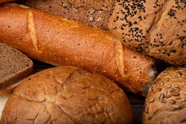 Close-up view of cut baguette bread with cob bread rye bread and others