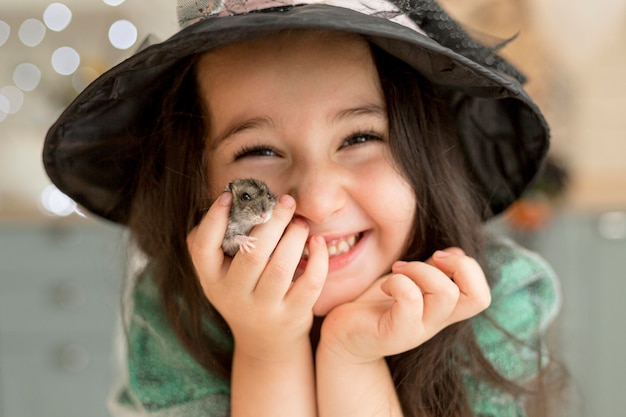 Close-up view of cute little girl holding a hamster