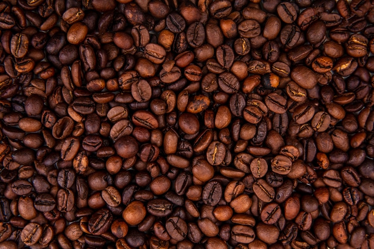 Free Photo close up view of dark fresh roasted coffee beans on coffee beans background