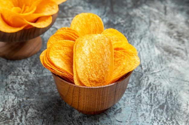 Close up view of delicious homemade potato chips on gray table