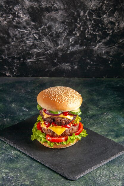 Close up view of delicious meat sandwich with tomatoes green on dark color tray on black surface with free space