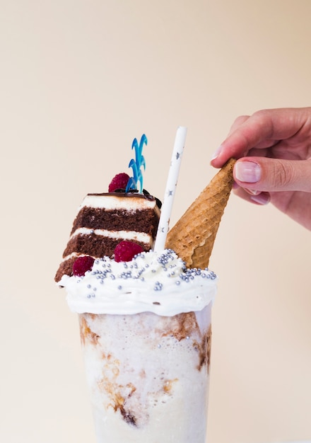 Close-up view of delicious milkshake with ice cream cone and cake