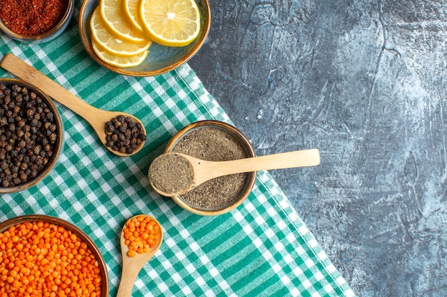 Free photo close up view of dinner background with different spices yellow pea on green stripped towel on dark table