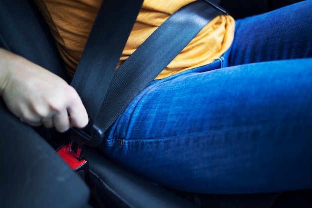 Close up view of driver putting seat belt on