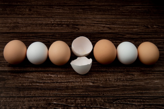 Foto gratuita vista del primo piano delle uova e del guscio d'uovo su fondo di legno