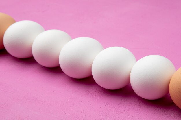 Close-up view of eggs on purple background with copy space