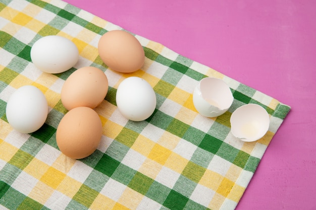 천으로 표면에 달걀 껍질과 복사 공간 보라색 배경에 계란의 근접 촬영보기