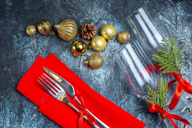 Close up view of fallen glass goblets and cutlery set decoration accessories on dark background