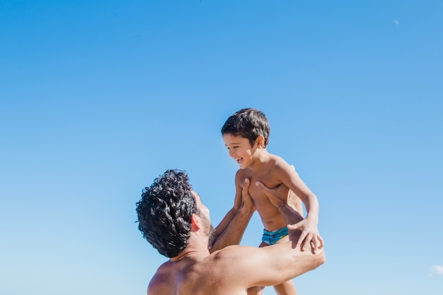 父親を持ち上げる息子の姿を見る