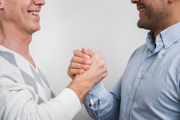 Close-up view of father and son holding hands