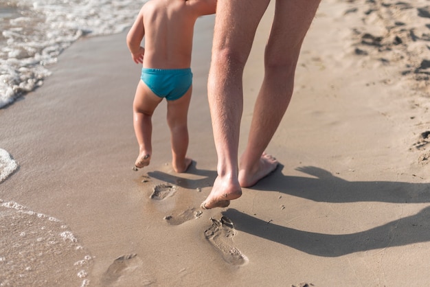 Close up view of father and son walking on the beach