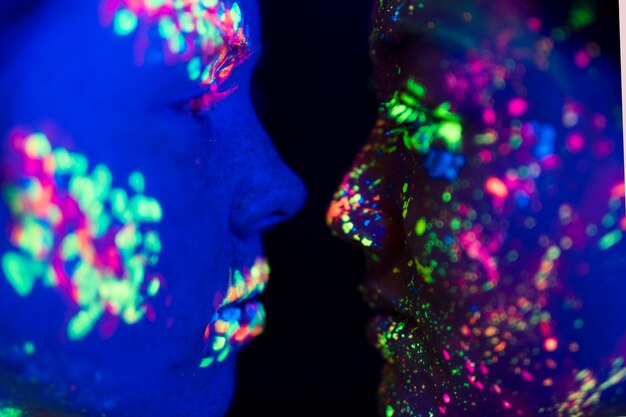 Close-up view of fluorescent make-up on people's face