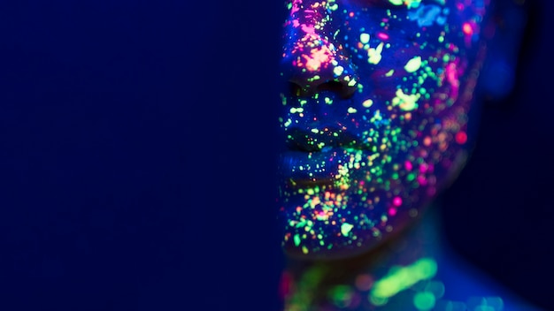 Close-up view of fluorescent make-up on person face