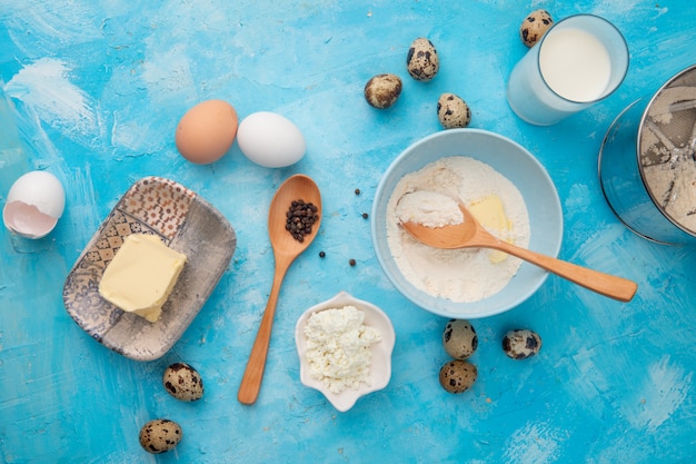 파란색 배경에 계란 후추와 우유 버터 코티지 치즈 가루로 음식의 근접 촬영보기