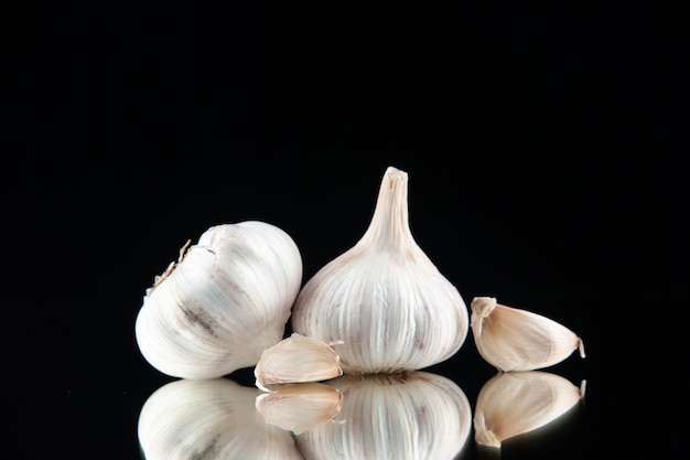 Free photo close up view of fresh garlic pods on black background with free space