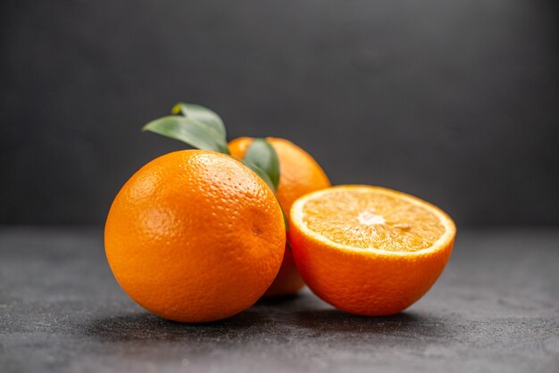 Close up view of fresh whole and sliced lemons on dark table 