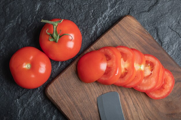 Close up view of freshly picked, juicy tomatoes on dark stone background. High quality photo
