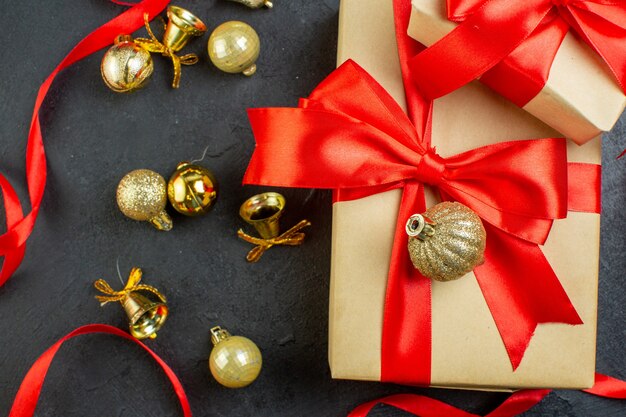 Close up view of gift box with red ribbon and decoration accessories on dark background