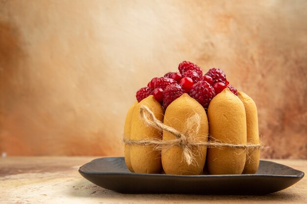 Close up view of a gift cake with fruits on the middle part of mixed color table