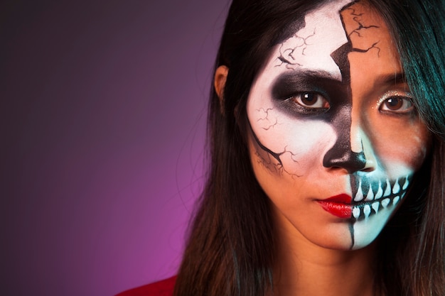 Close up view of girl with makeup and halloween mask