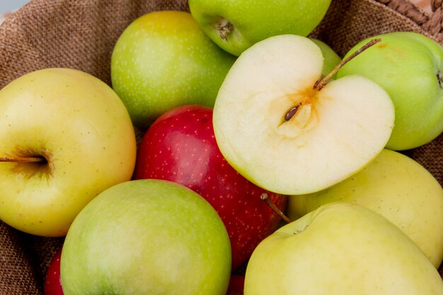 Close-up view of green yellow red apples in basket as background