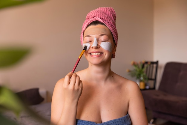 Close up view of happy woman with mask on face with close eyes at home