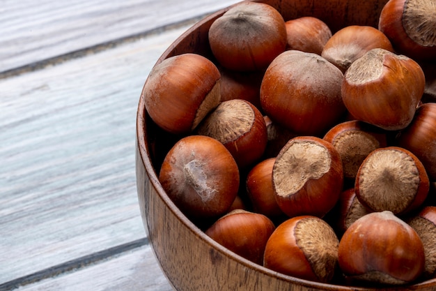Close up view of hazelnuts in a bowl on wooden rustic